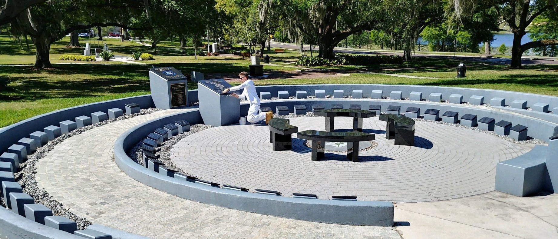 Worker Cleaning Monument In A Park