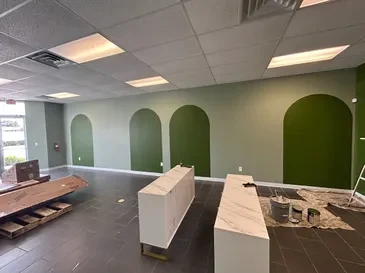 Interior with deep green arched accent panels above a dark tile floor