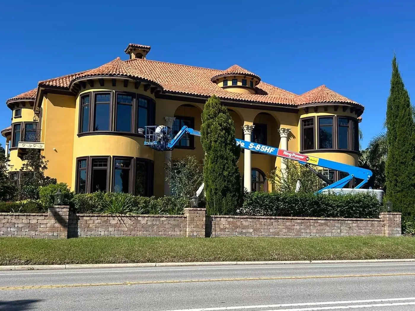 Mediterranean-style Lakeland home being repainted from a boom lift by Mike's Painting