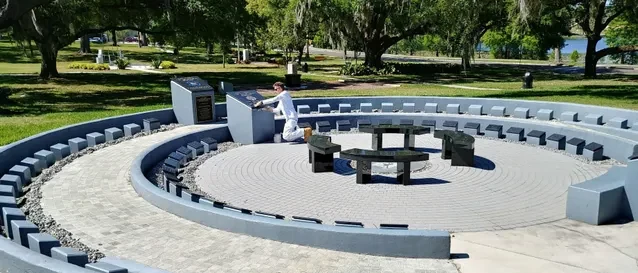 Worker pressure washing the concrete seating and paving of an outdoor amphitheater