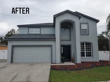Two-story stucco home after an exterior repaint in slate grey